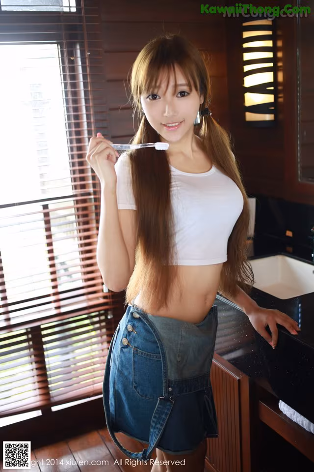 A woman brushing her teeth in a bathroom.