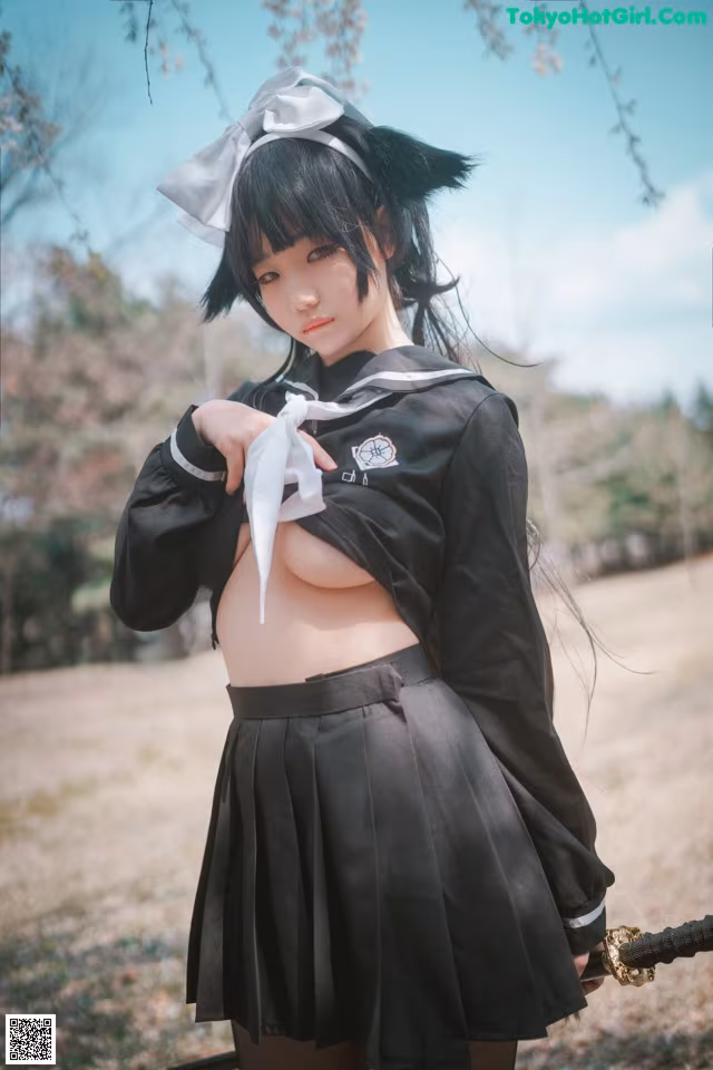 A woman in a school uniform holding a sword.
