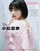 A woman in a pink sweater is posing for a magazine.