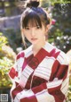 A woman in a red and white kimono posing for a picture.