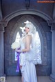 A woman in a wedding dress holding a bouquet of flowers.