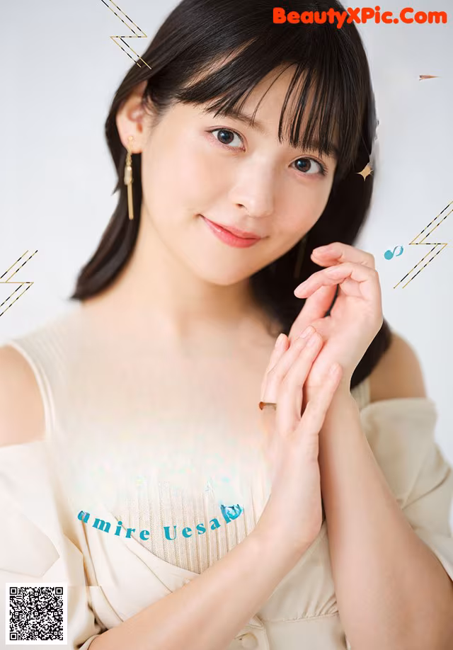 A woman in a white dress posing for a magazine cover.