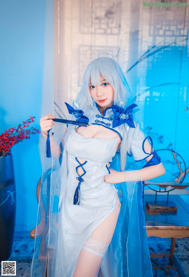 A woman in a blue and white dress holding a knife.