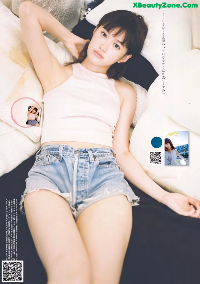 A woman laying on top of a bed next to pillows.