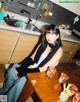 A woman sitting at a table in a kitchen.